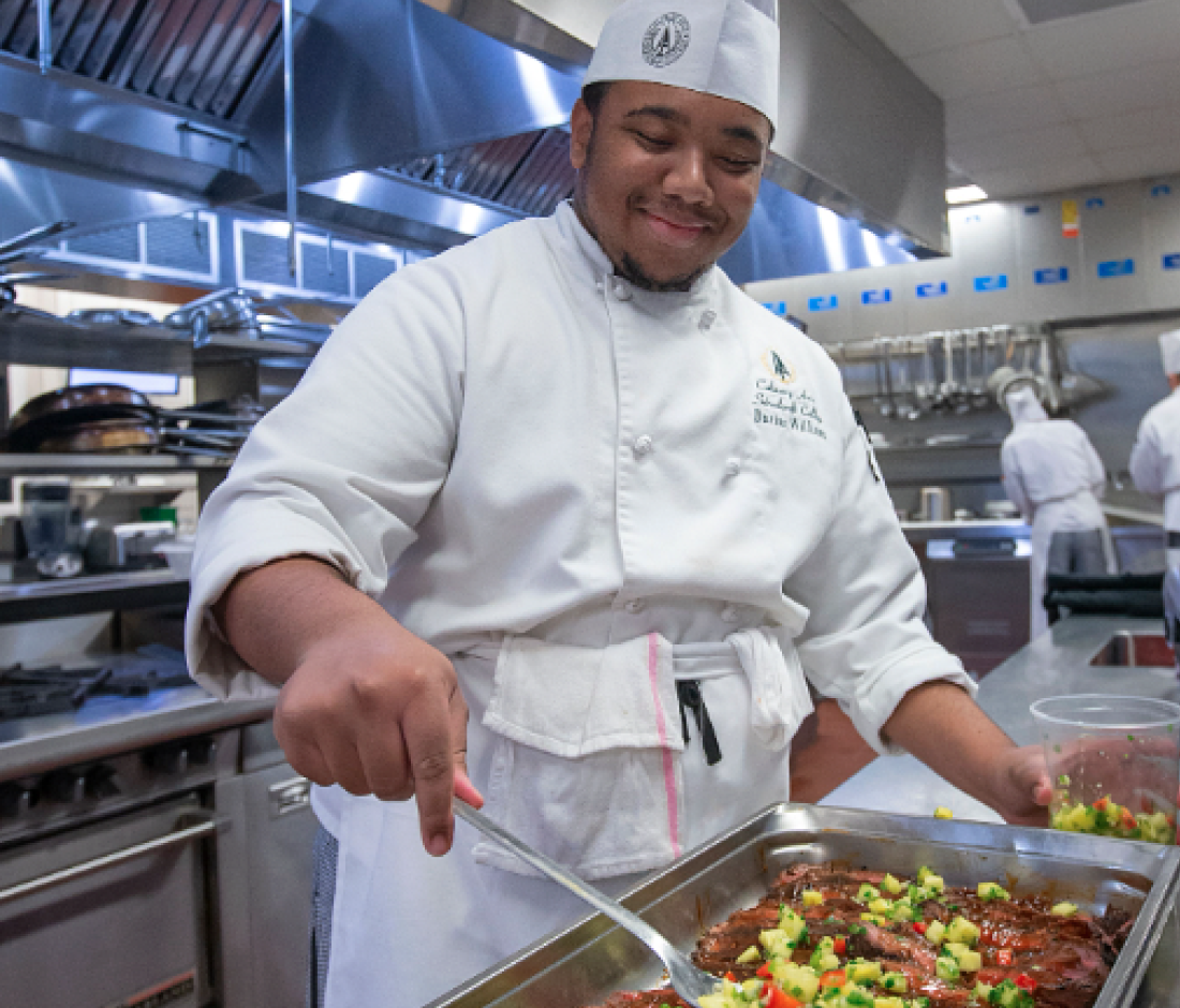 student preparing large tray of food