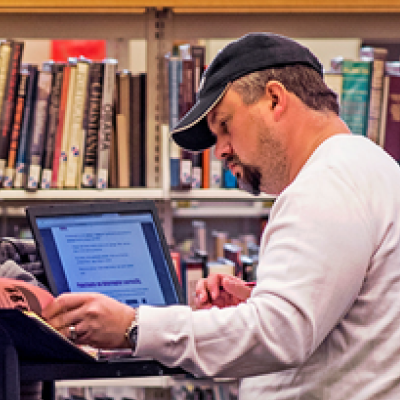 student on laptop in library