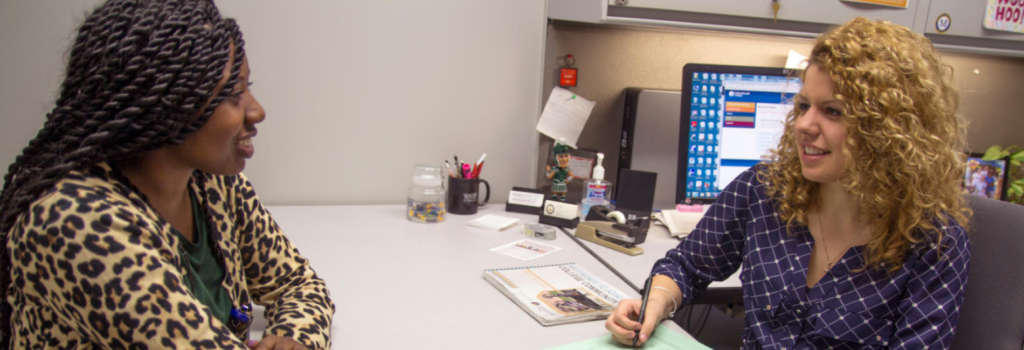 An advisor talking with a student in office