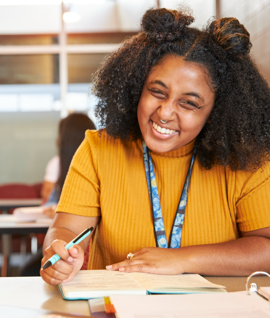 Student smiling at her desk