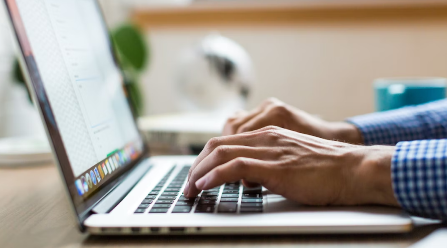 hands typing on laptop