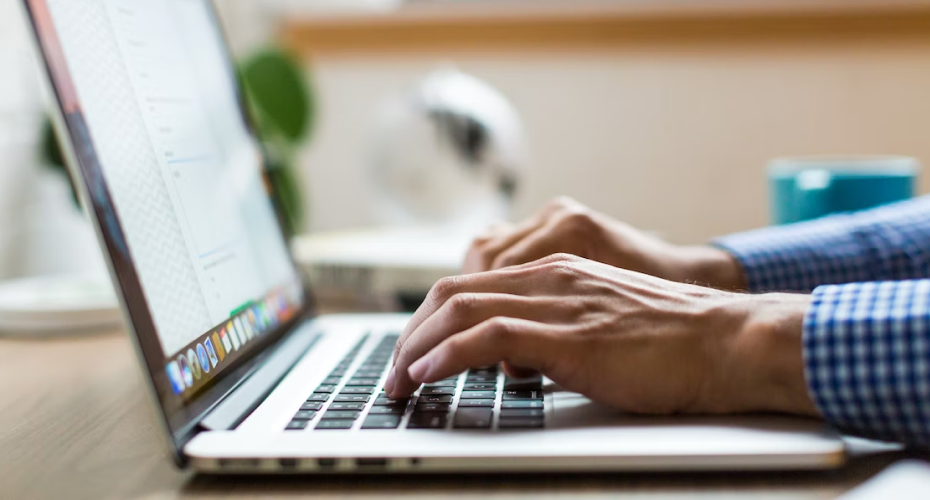 hands typing on laptop