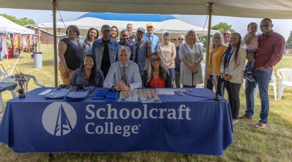 Large group photo in front of the "Schoolcraft College" table