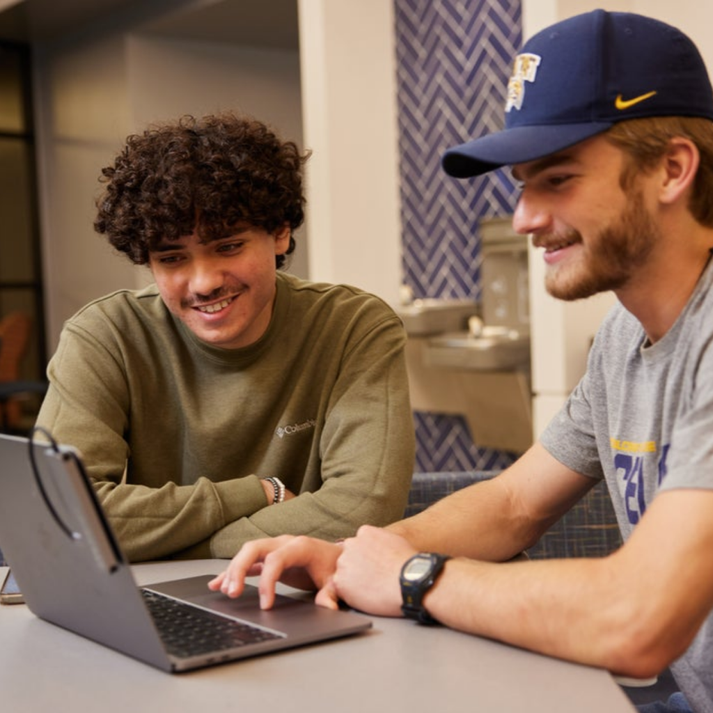 two students looking at laptop screen