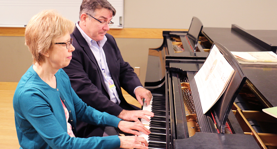 two people playing piano