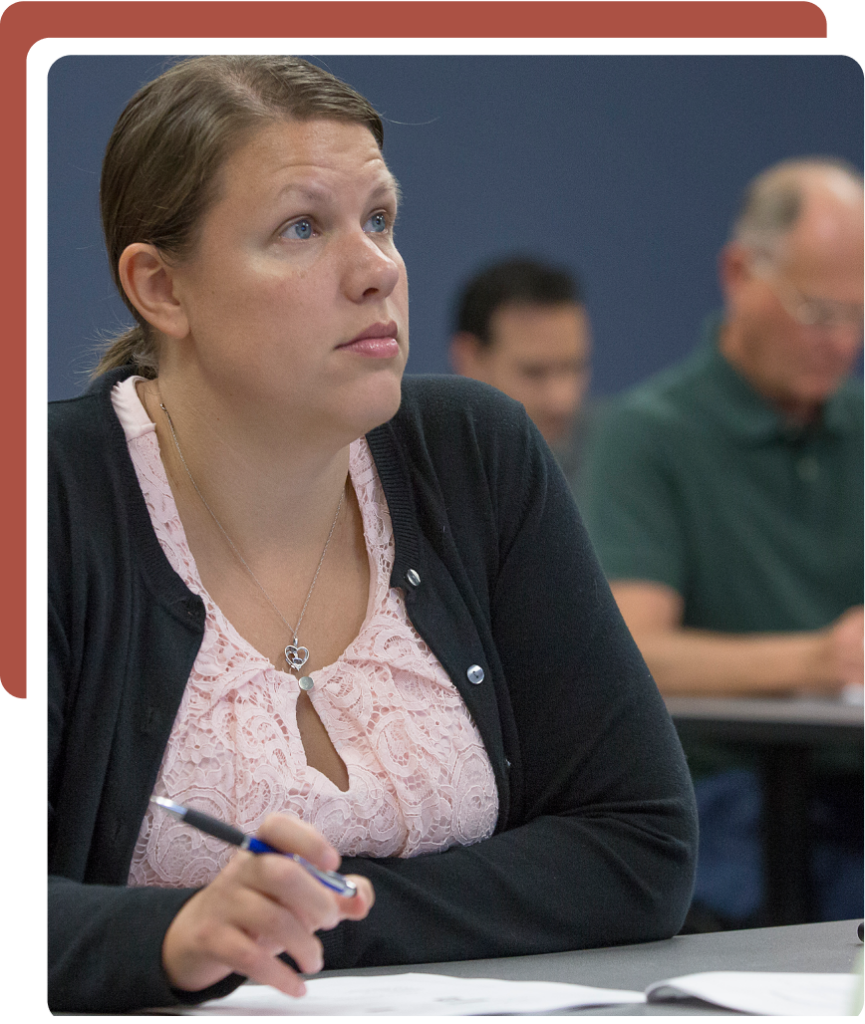 woman taking notes during class