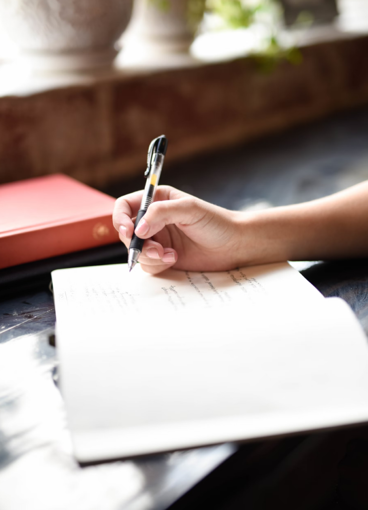 person writing in notebook