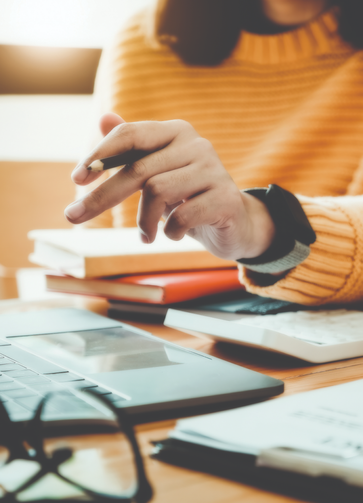 person working at desk of laptop and papers