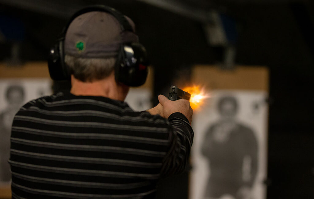 Student firing a gun at a target at the firing range