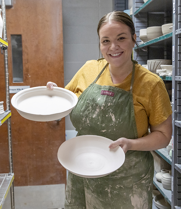 person holding pottery bowls