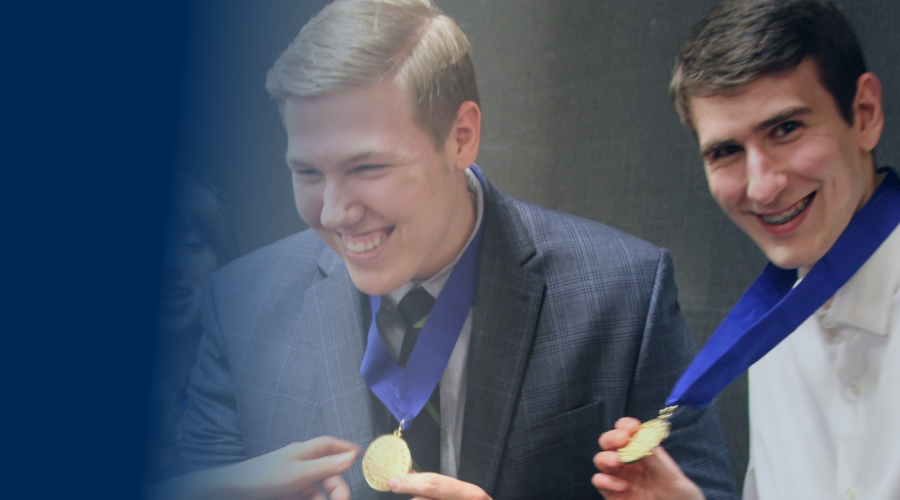 Students smiling holding medals