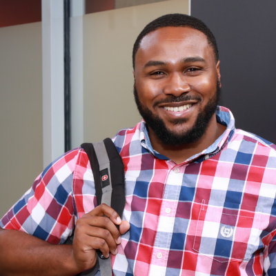 student smiling with backpack