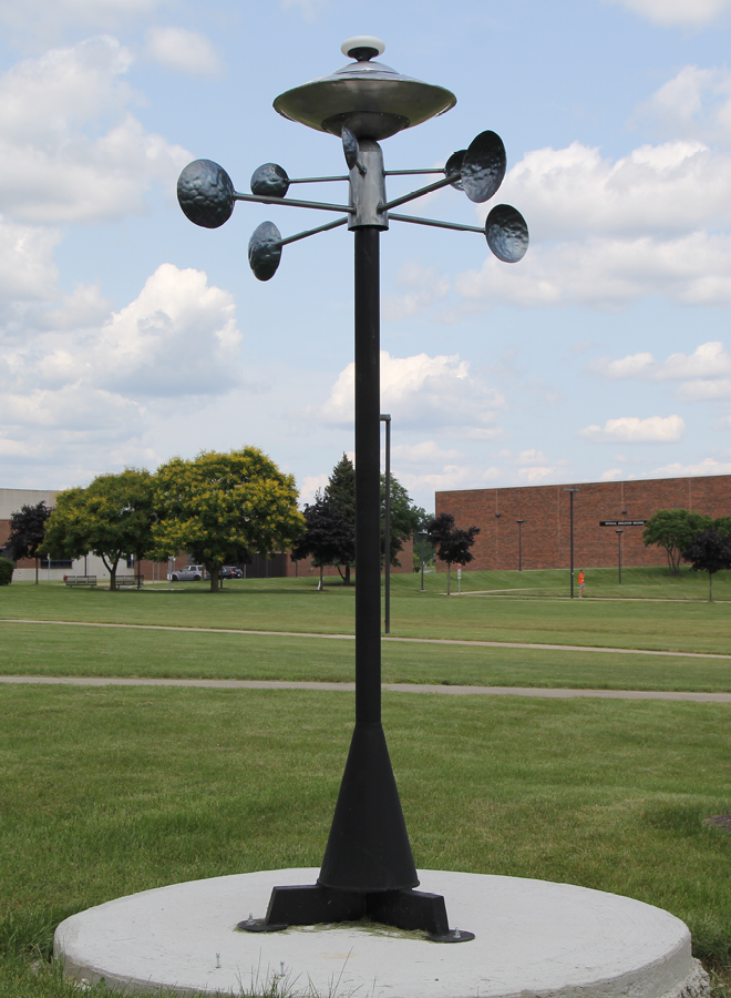 metal sculpture of pole and compass-like crossing bars