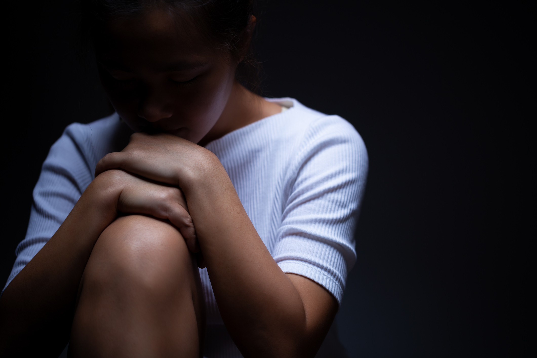 Person sitting down in dark