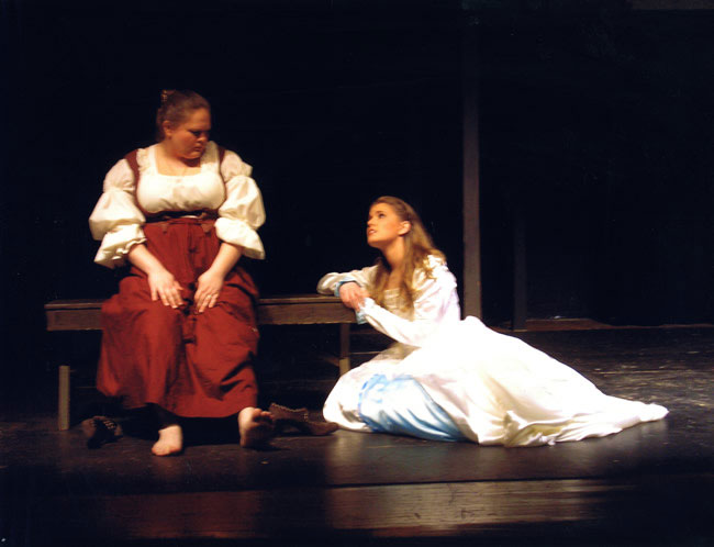 A stage scene of two actresses talking.