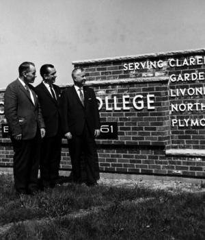 three men at a Schoolcraft sign