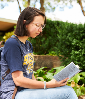 Student reading a book outside