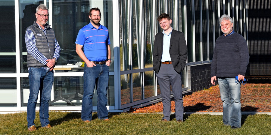 Four people standing in front of a building