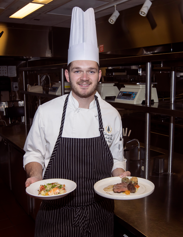 Austin Hannah with two dishes in hands