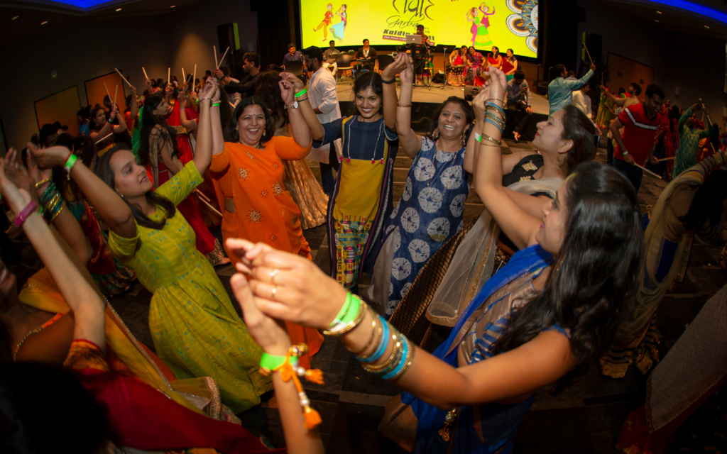 A group of people dancing in a circle holding hands