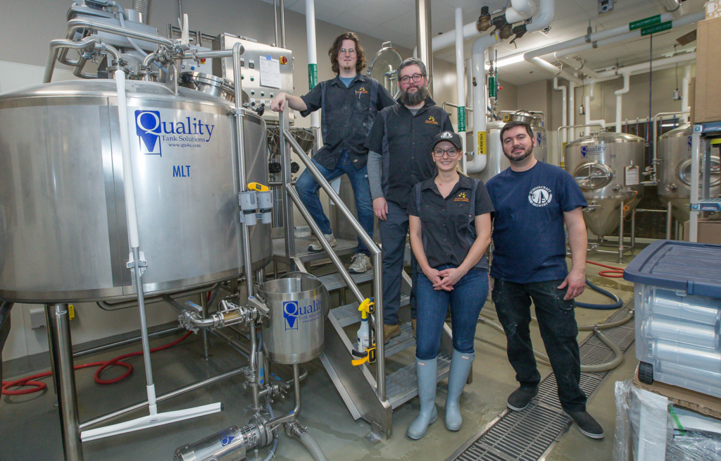 Four brewers standing in brewery