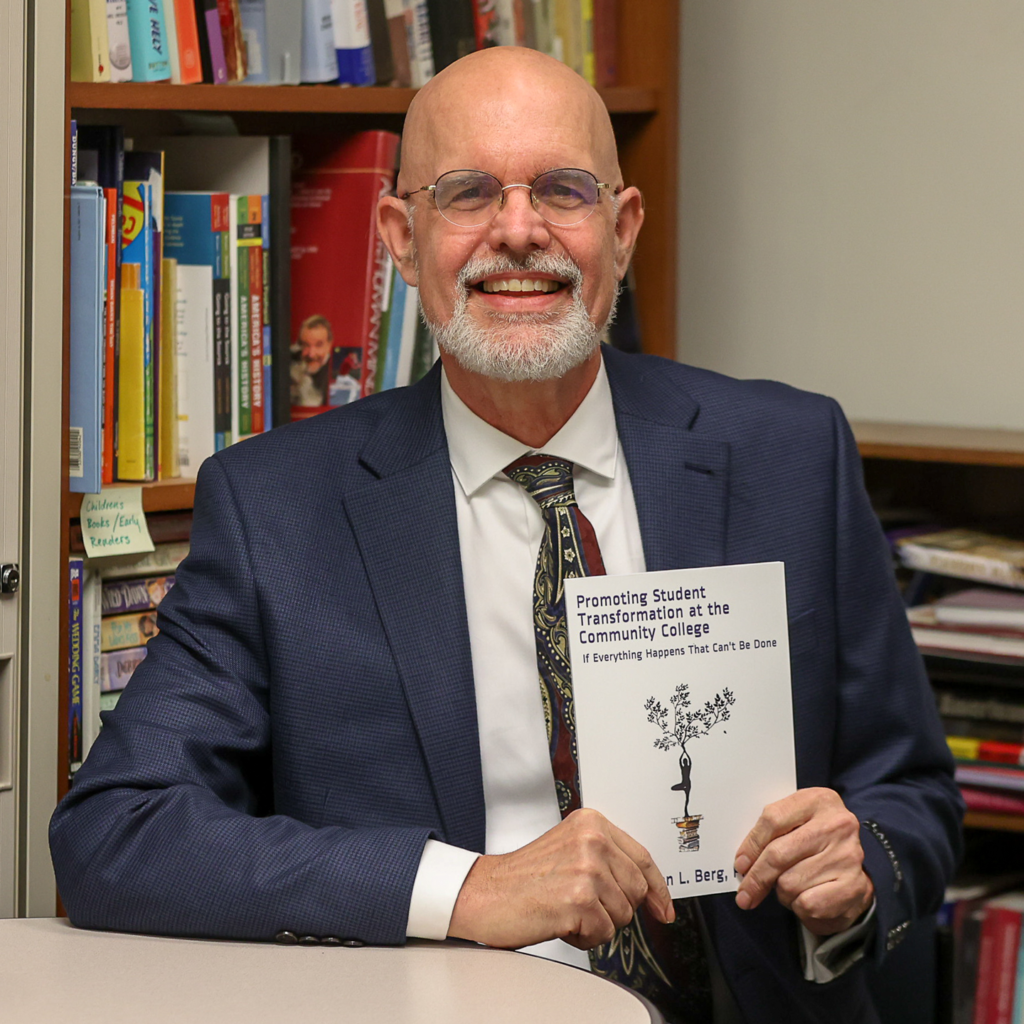 Author holding up his book smiling