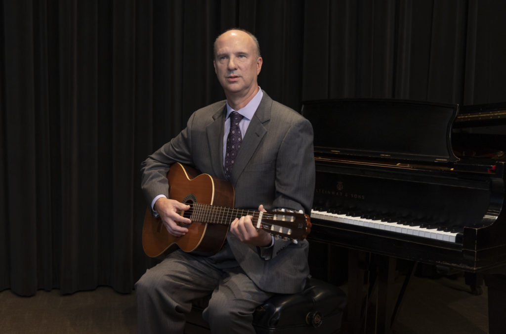 Dr. Frederick Moss playing guitar