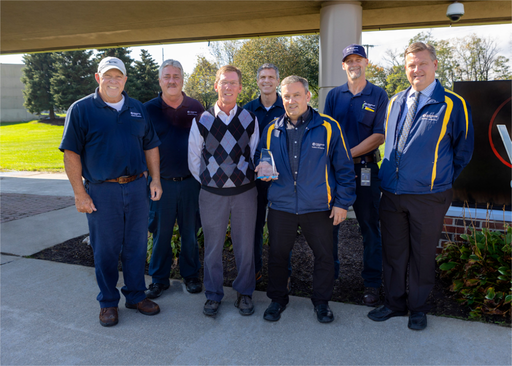 Group of men holding a crystal-style award