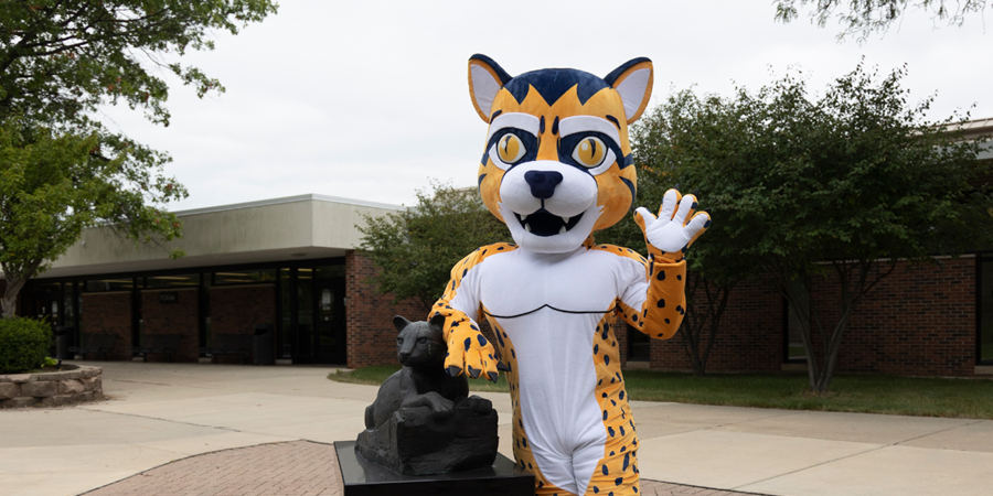 An Ocelot mascot waving