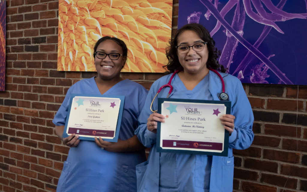 Two nursing students holding awards