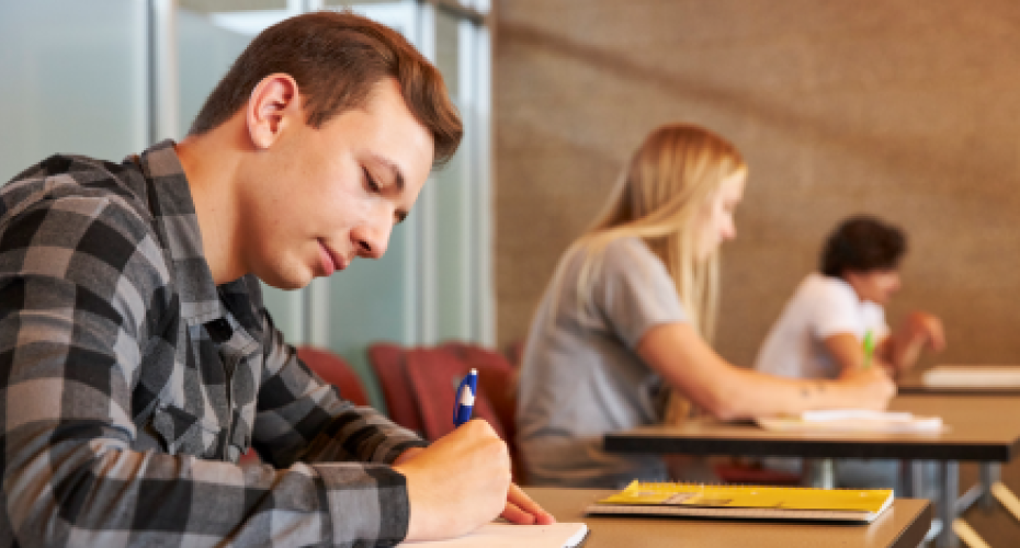 Student writing in a classroom