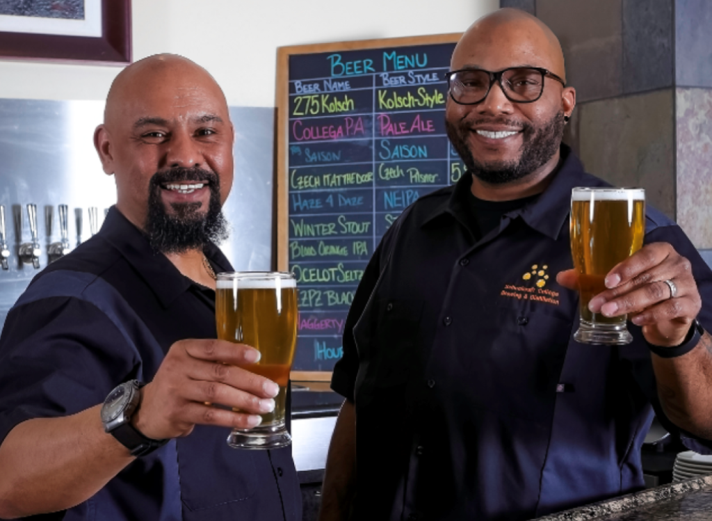 Two people holding up a beer