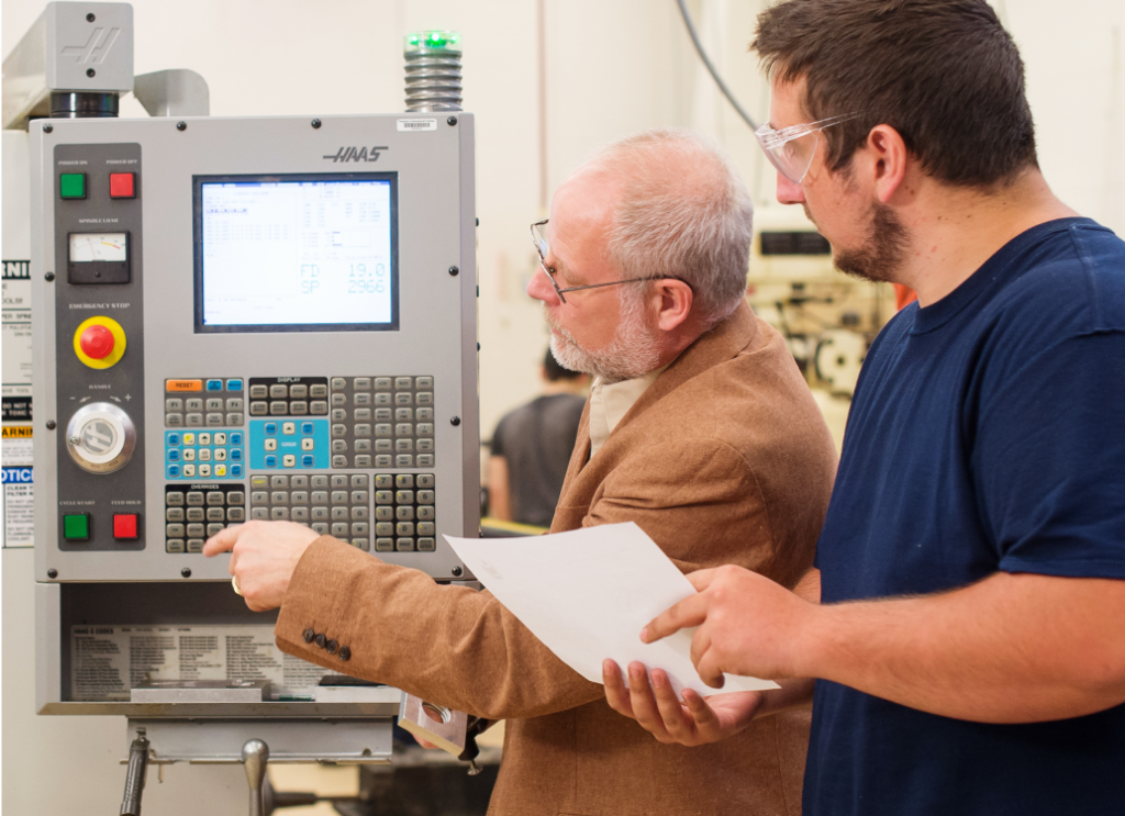 Two people looking at machinery