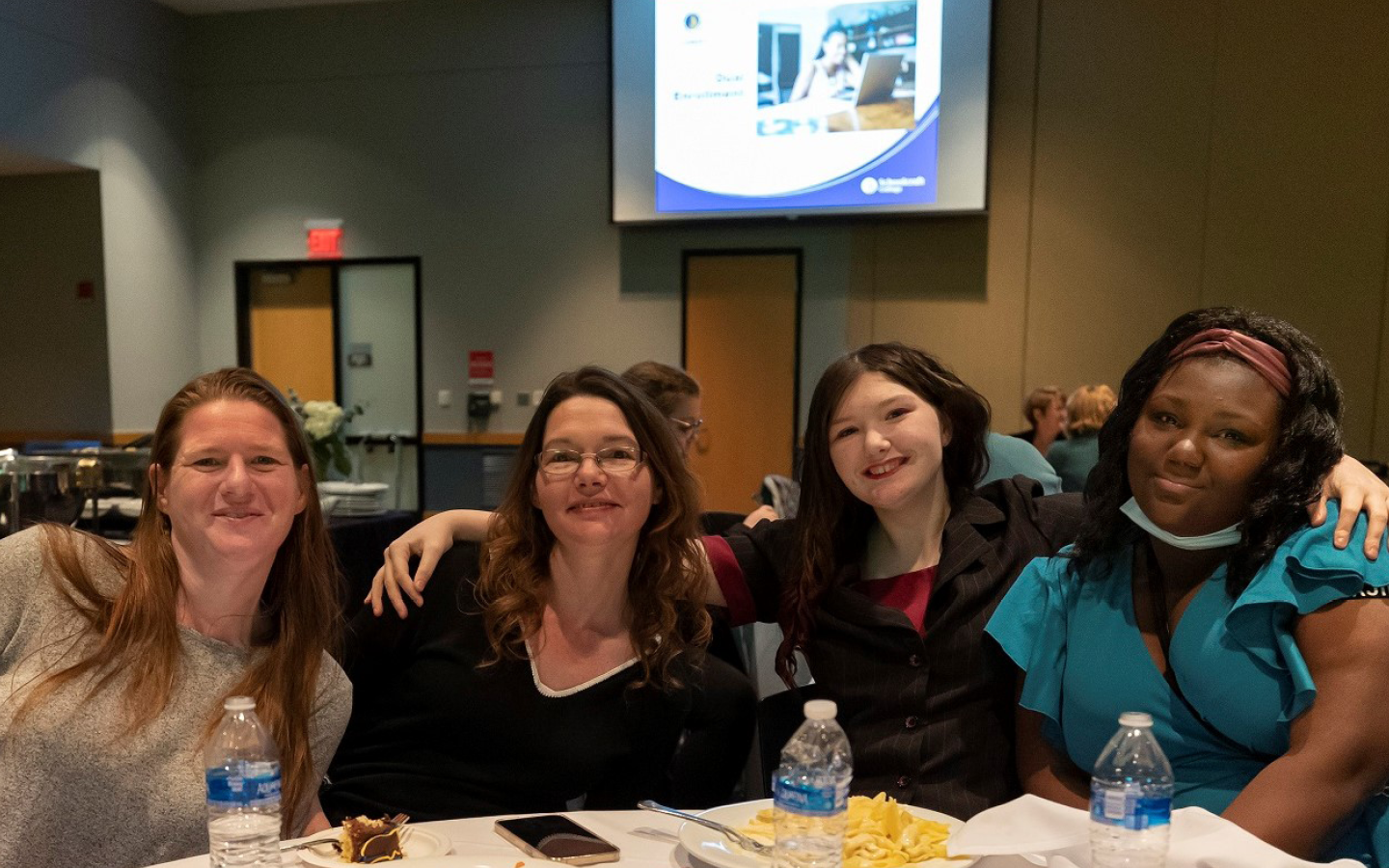 Four attendees smiling for a photo