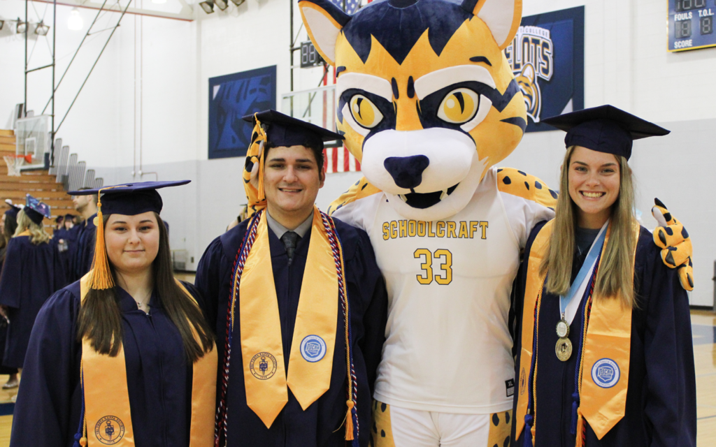 graduates take photo with the ocelot mascot