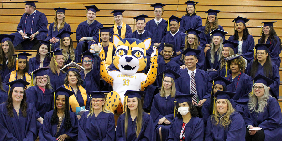 Student athletes pose with ocelot mascot