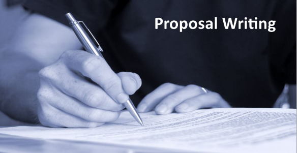 hands writing with a pen onto a sheet of paper and a banner that reads: "proposal writing"