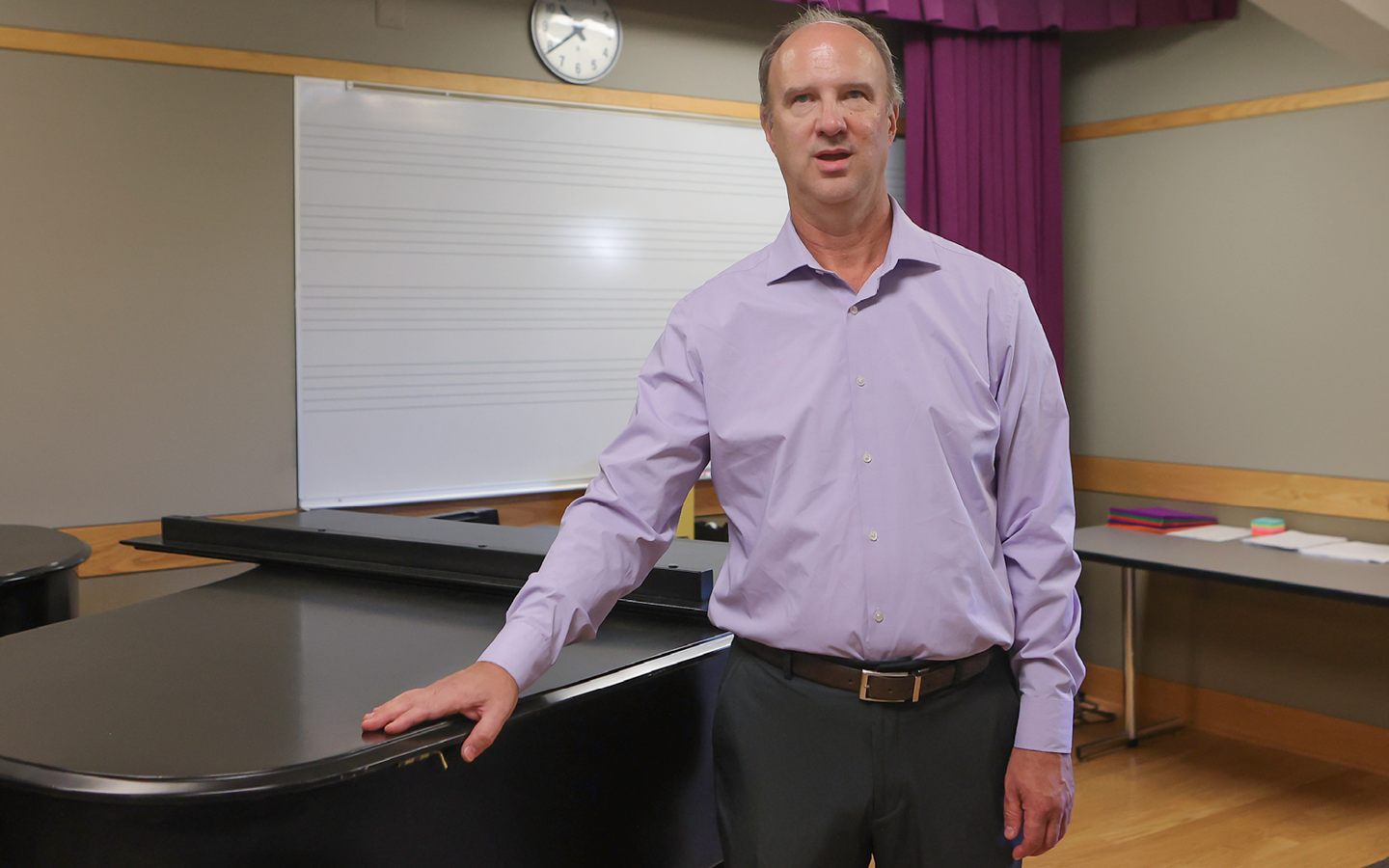 Dr. Frederick Moss standing beside piano