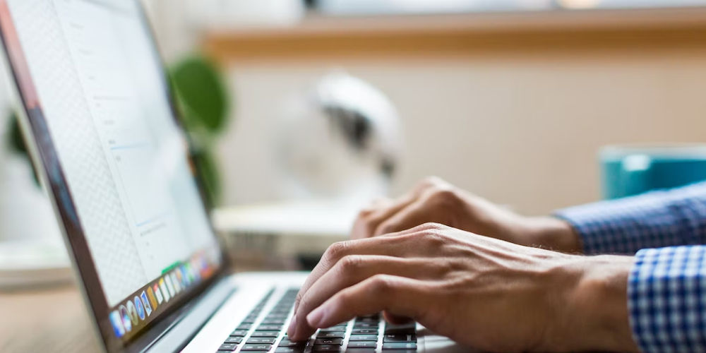 hands typing on laptop