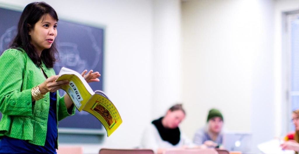 teacher instructing holding book