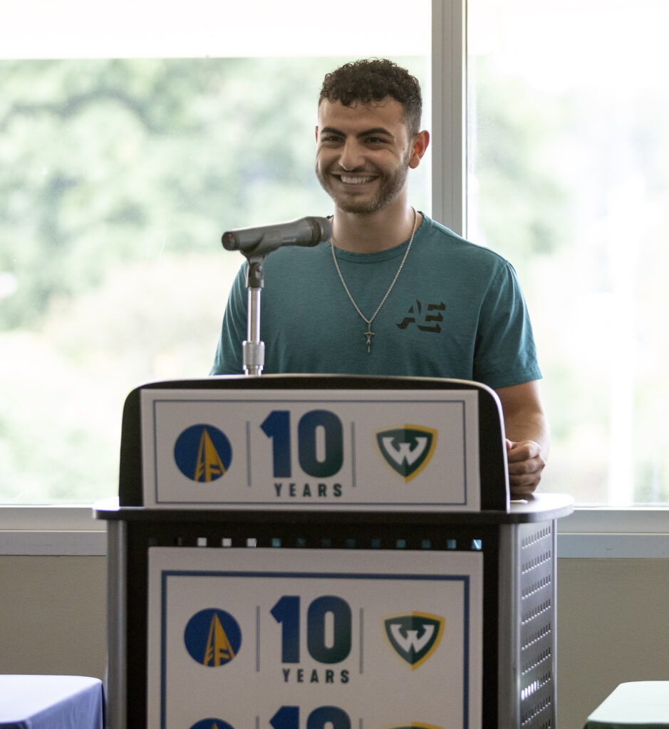 student at a podium smiling