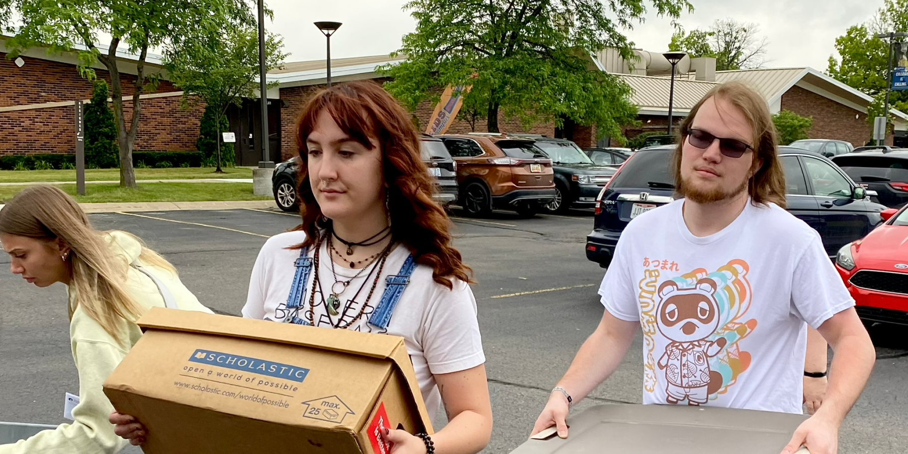 students walking and carrying boxes