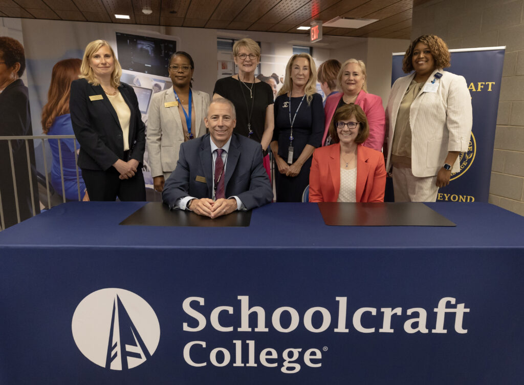 group photo of administrators behind Schoolcraft College table
