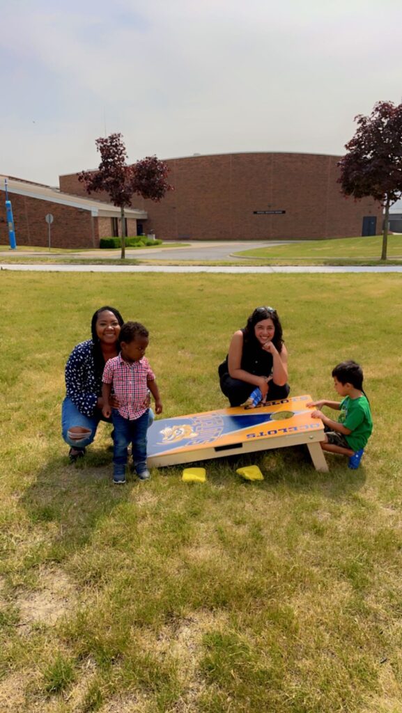 young children playing corn hole yard game