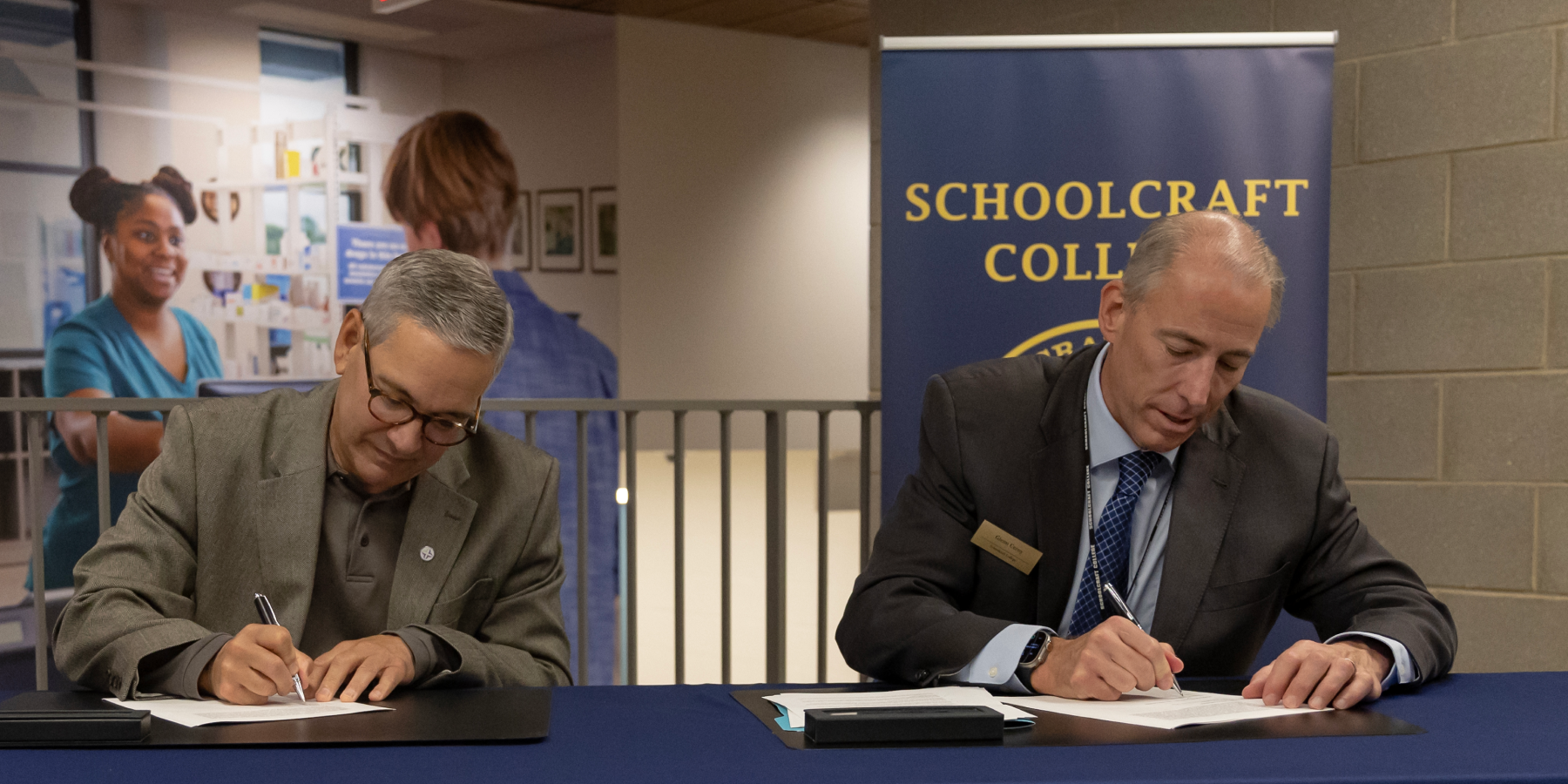 leadership at a table signing the agreement