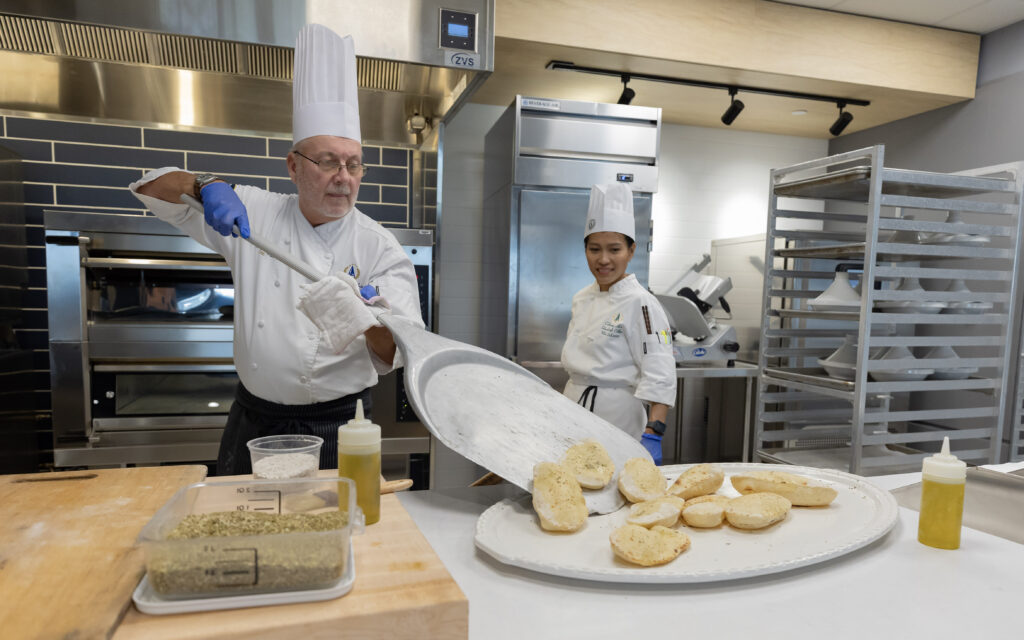 Chefs migrating bread onto a plate