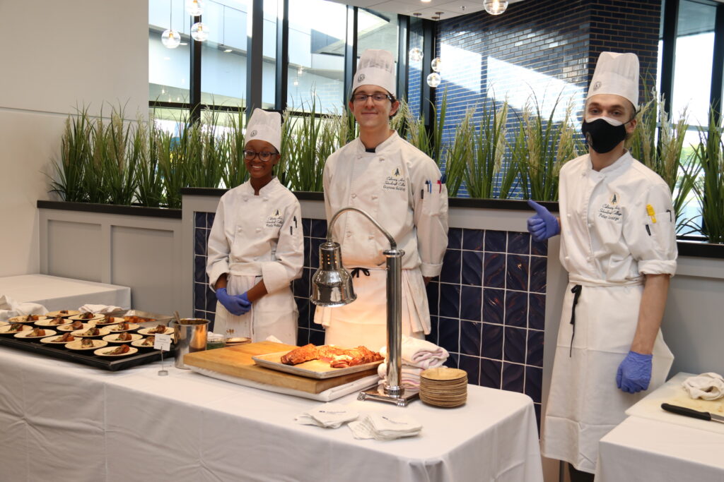 Student chefs behind a table of food