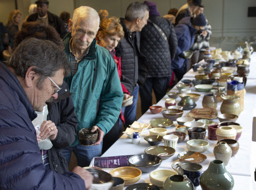 people looking at tables of ceramic bowls