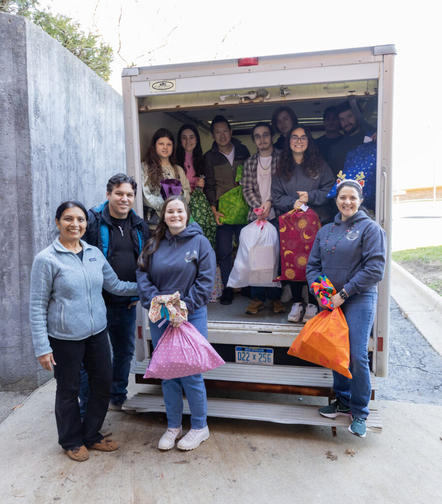Large group pose for photo inside an open truck