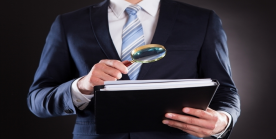 business person holding magnifying glass